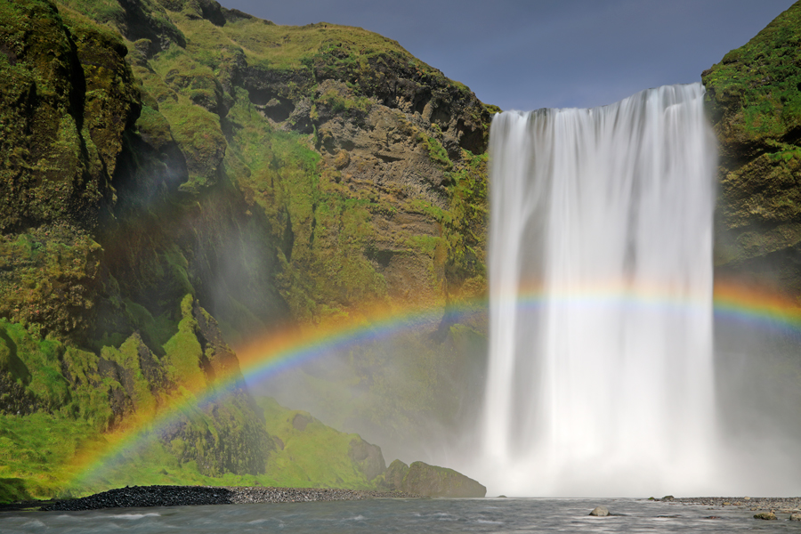 Bei direkter Bestrahlung mit Sonnenschein bildet sich am Skogafoss ein intensiver Regenbogen.