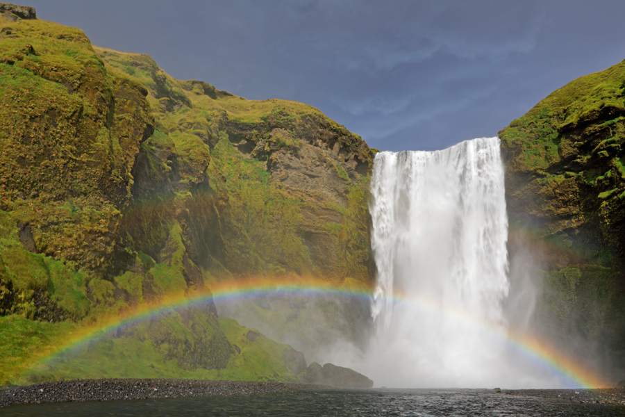 Bei direkter Bestrahlung mit Sonnenschein bildet sich am Skogafoss ein intensiver Regenbogen.